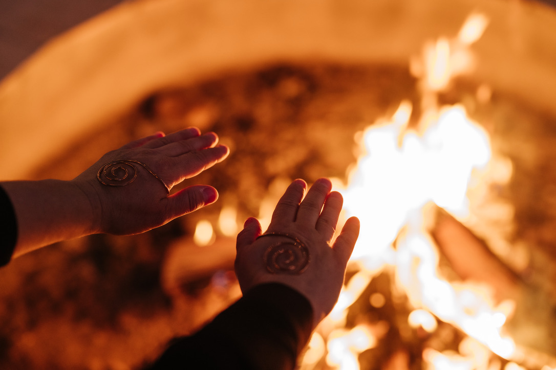 Hands held toward the fire